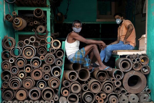 Công nhân đeo khẩu trang tại cửa hàng bán ống sắt ở Kolkata, Ấn Độ - Sputnik Việt Nam