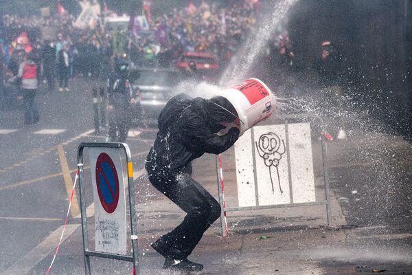 Người biểu tình đội chiếc xô tránh súng nước của cảnh sát tại cuộc biểu tình phản đối của các nhân viên ngành y ở Nantes, Pháp - Sputnik Việt Nam