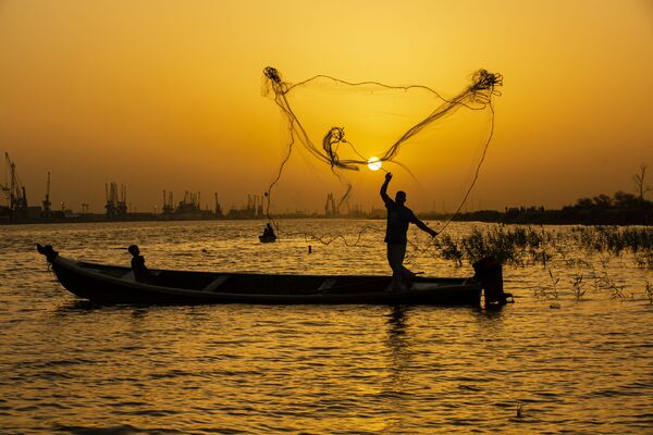 Ngư dân tung lưới lúc hoàng hôn trên sông Shatt al-Arab ở thành phố Basra, Iraq - Sputnik Việt Nam