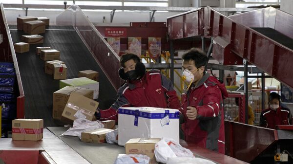 Nhân viên dịch vụ giao hàng cho đại gia thương mại điện tử Trung Quốc JD.com sắp xếp bưu kiện tại trung tâm phân phối ở Bắc Kinh - Sputnik Việt Nam