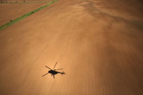 Bóng chiếc trực thăng MI-8AMTSh đang bay trên cánh đồng - Sputnik Việt Nam
