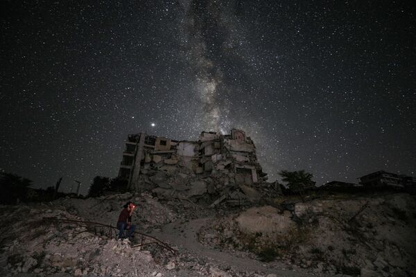 Tòa nhà bị trúng bom trên nền trời đầy sao ở tỉnh Idlib, Syria - Sputnik Việt Nam