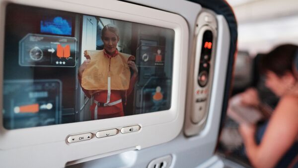 Trên màn hình trước ghế trong khoang máy bay hiển thị cách hành động trong trường hợp xảy ra tai nạn. - Sputnik Việt Nam