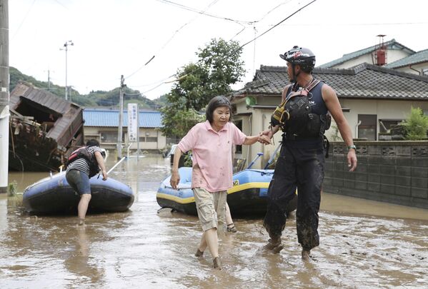 Nhân viên cứu hộ giúp người phụ nữ trong lúc sơ tán ở tỉnh Kumamoto, Nhật Bản - Sputnik Việt Nam