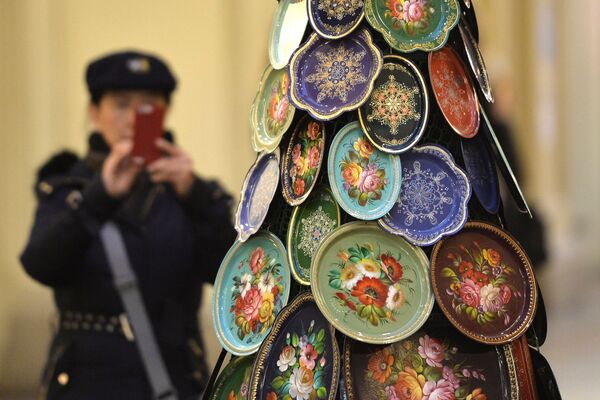 Du khách chụp ảnh cây thông Năm mới được ghép từ các khay truyền thống Zhostovo trong cửa hàng GUM, Moskva. - Sputnik Việt Nam