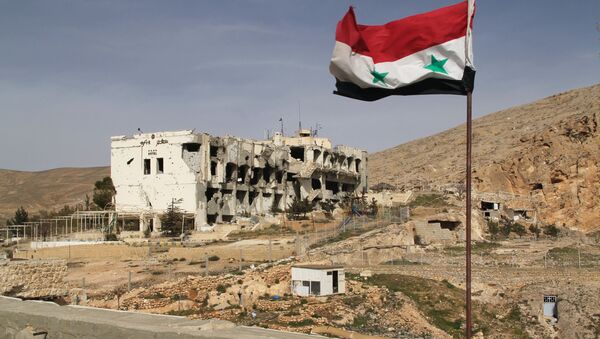 Cờ Syria trước ngôi nhà bị tàn phá tại thị trấn Maaloula - Sputnik Việt Nam