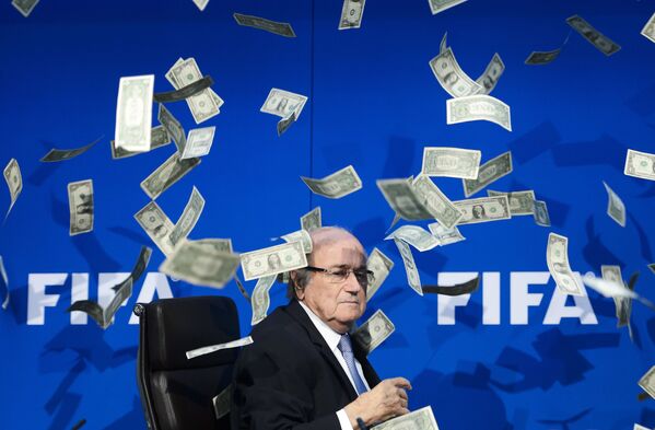 Chủ tịch FIFA Joseph Blatter nhìn những đồng đô la giả mà những người biểu tình ném xuống trong cuộc họp báo tại trụ sở ở Zurich - Sputnik Việt Nam